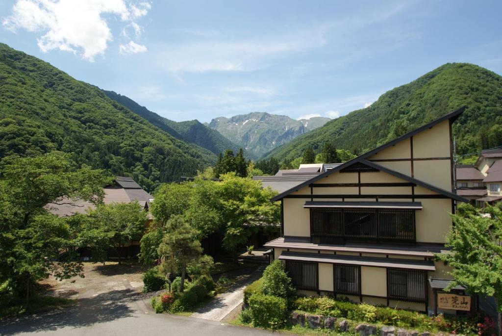 a view of a building with mountains in the background at Super Hydrogen Rich Spa Yado Kanzan in Minakami