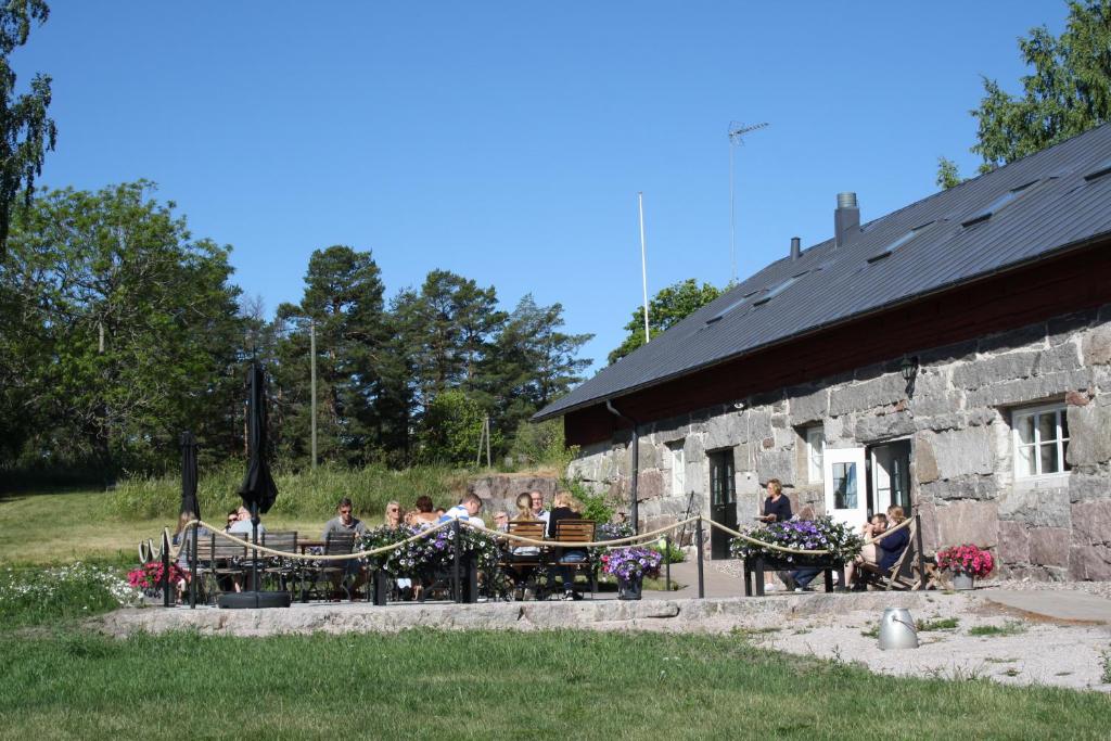 a group of people sitting at a table outside of a building at Hotel Stallbacken Nagu in Nauvo