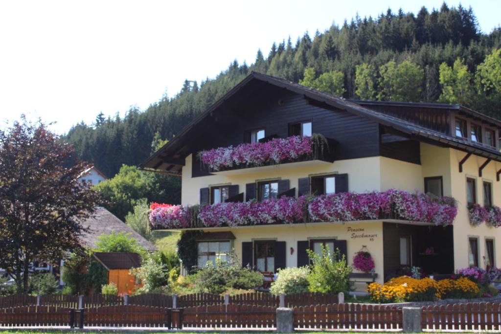 ein Gebäude mit Blumen auf der Seite in der Unterkunft Pension Speckmoser in Bad Mitterndorf