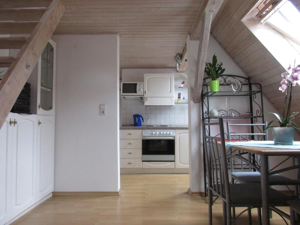 a kitchen with white cabinets and a table with chairs at Ferienwohnung Regina in Albstadt