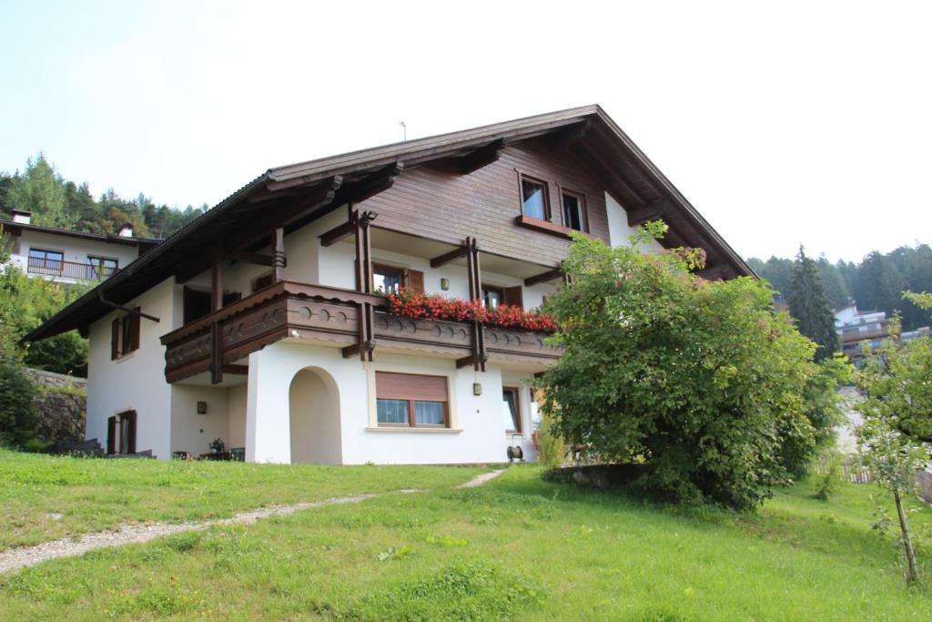 a house with a balcony on top of a field at Haus Peskoller in Perca
