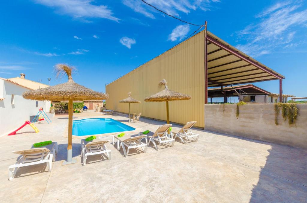 eine Terrasse mit Stühlen und Sonnenschirmen sowie einem Pool in der Unterkunft Sa Caseta De Ses Vaques. Son Covas (Sa Vaqueria 2) in Campos
