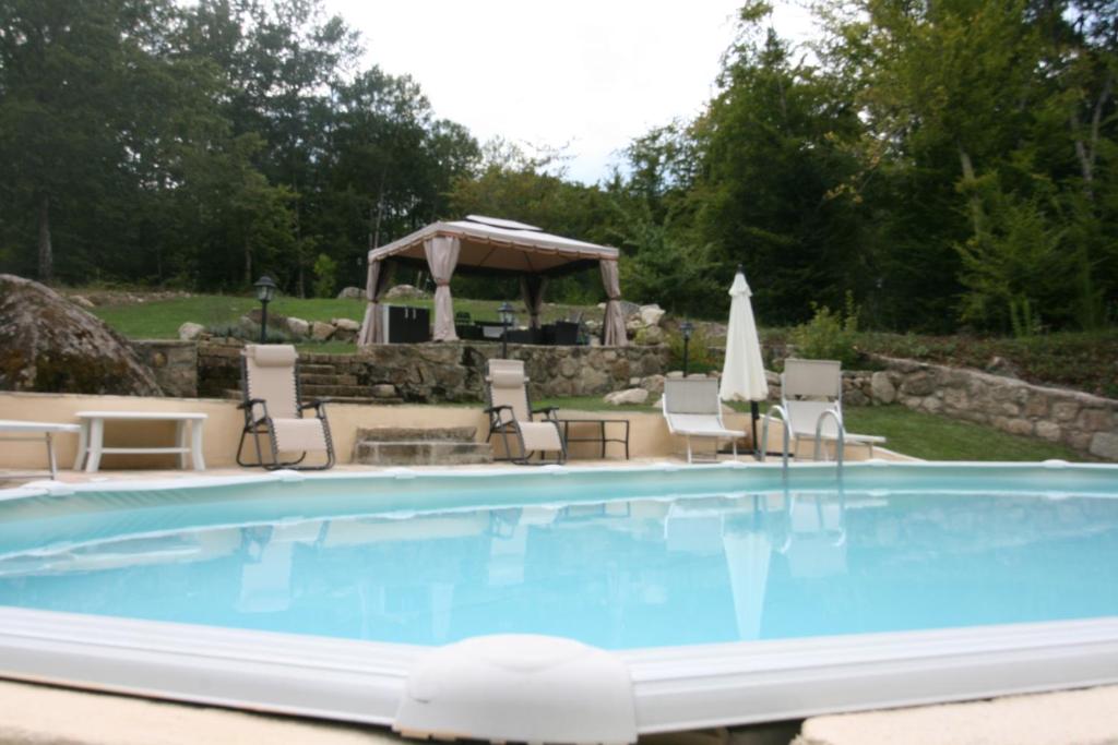 einen Pool mit Stühlen und einem Pavillon in der Unterkunft Il Mulino del Rigualdo in Torniella