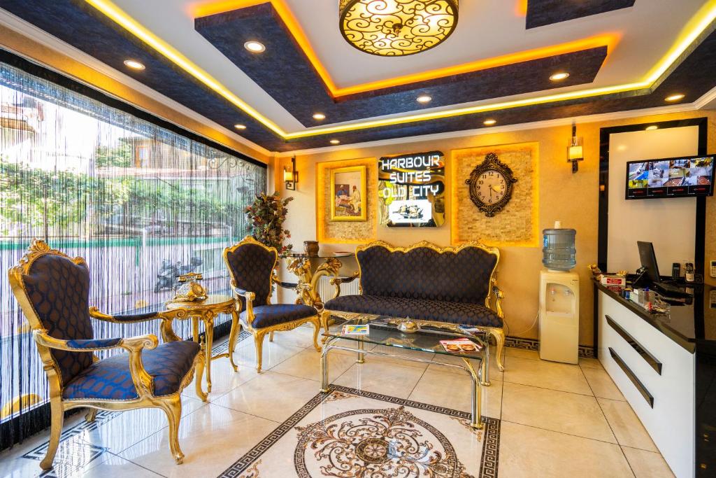 een woonkamer met stoelen en een tafel en een televisie bij Harbour Suites Old City in Istanbul