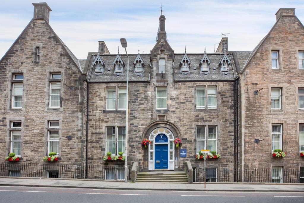 un antiguo edificio de ladrillo con una puerta azul en Leonardo Edinburgh City en Edimburgo