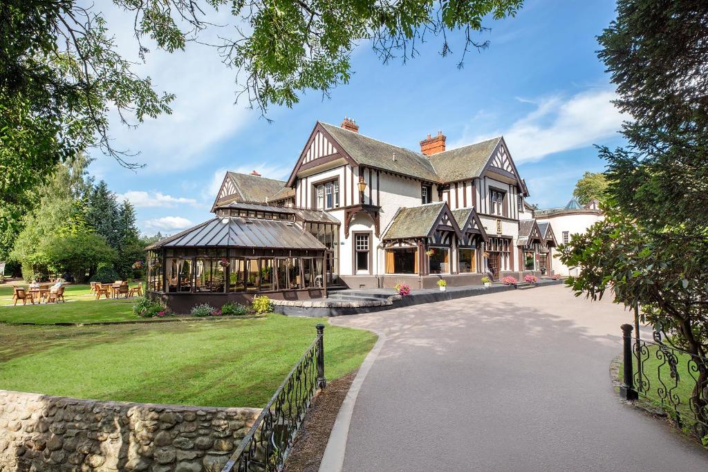 a large house with a stone wall at Leonardo Boutique Huntingtower Perth in Perth