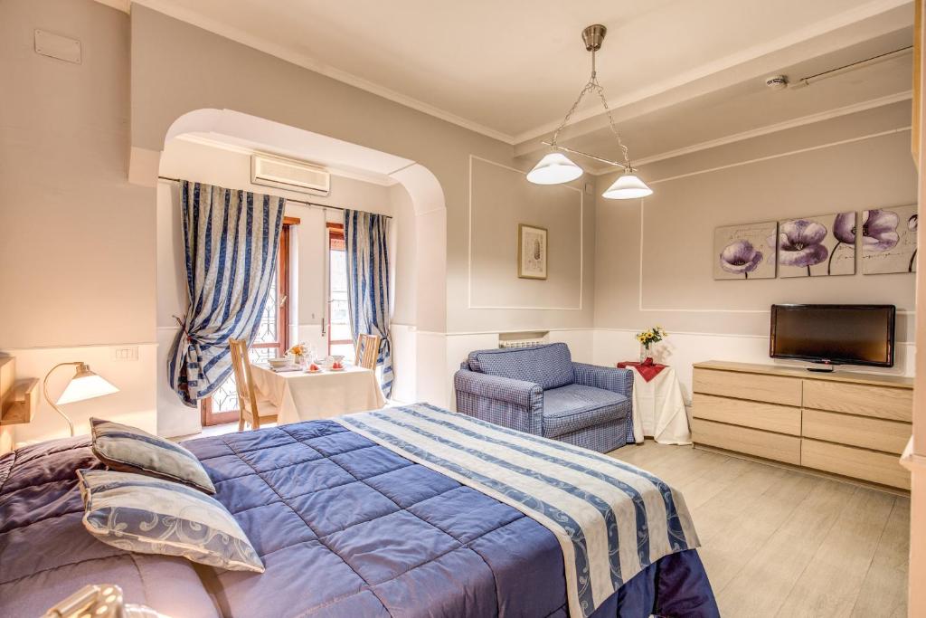 a bedroom with a bed and a chair and a television at Hotel Residence Magnolia in Rome