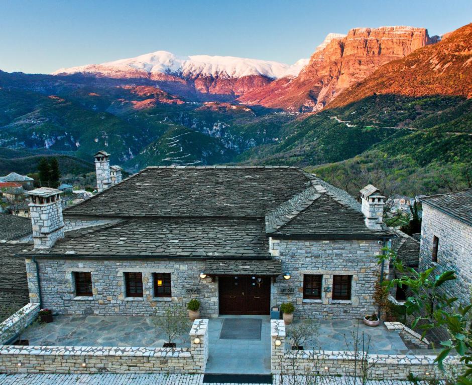 a stone house with a mountain in the background at Aristi Mountain Resort in Aristi