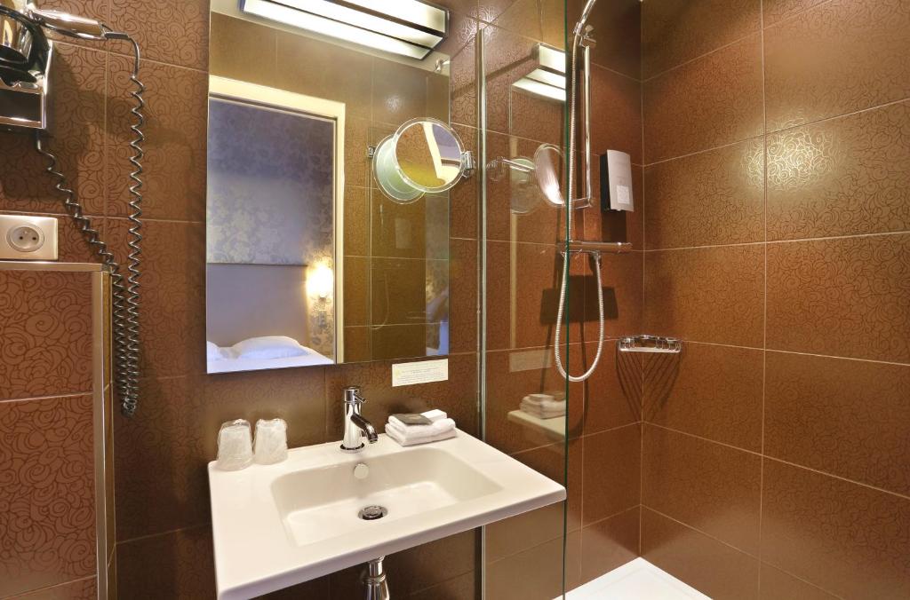 a bathroom with a sink and a shower at Hôtel de Paris in Besançon