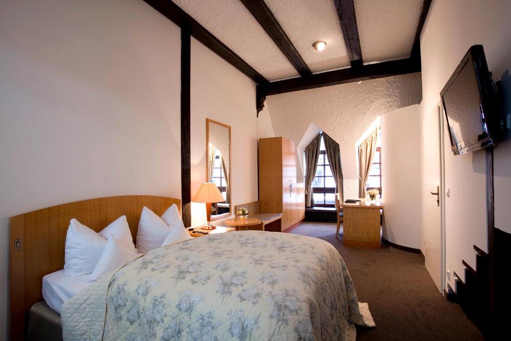 a bedroom with a bed and a television in a room at Hotel Traube in Stuttgart