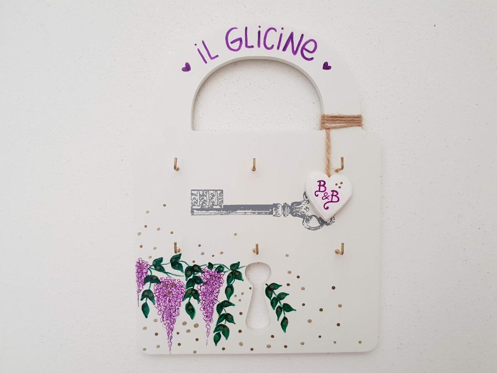 Una puerta blanca con una llave y flores. en B&B Il Glicine, en Badia Polesine