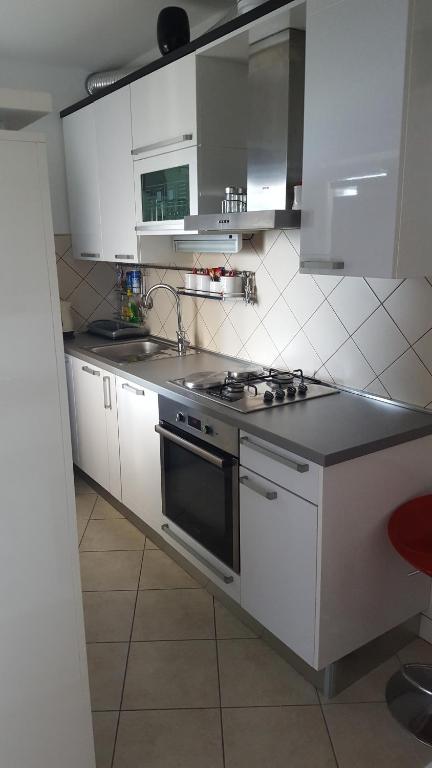 a kitchen with white cabinets and a stove top oven at Apartman Astra in Ploče