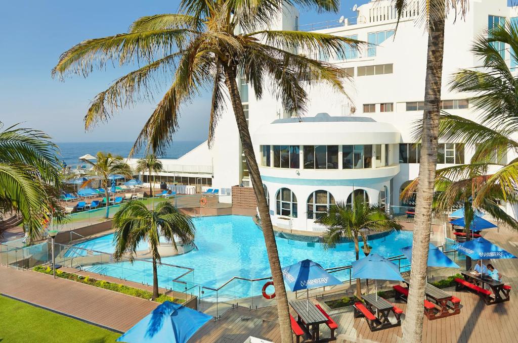 an aerial view of a hotel with a pool and palm trees at First Group La Montagne in Ballito