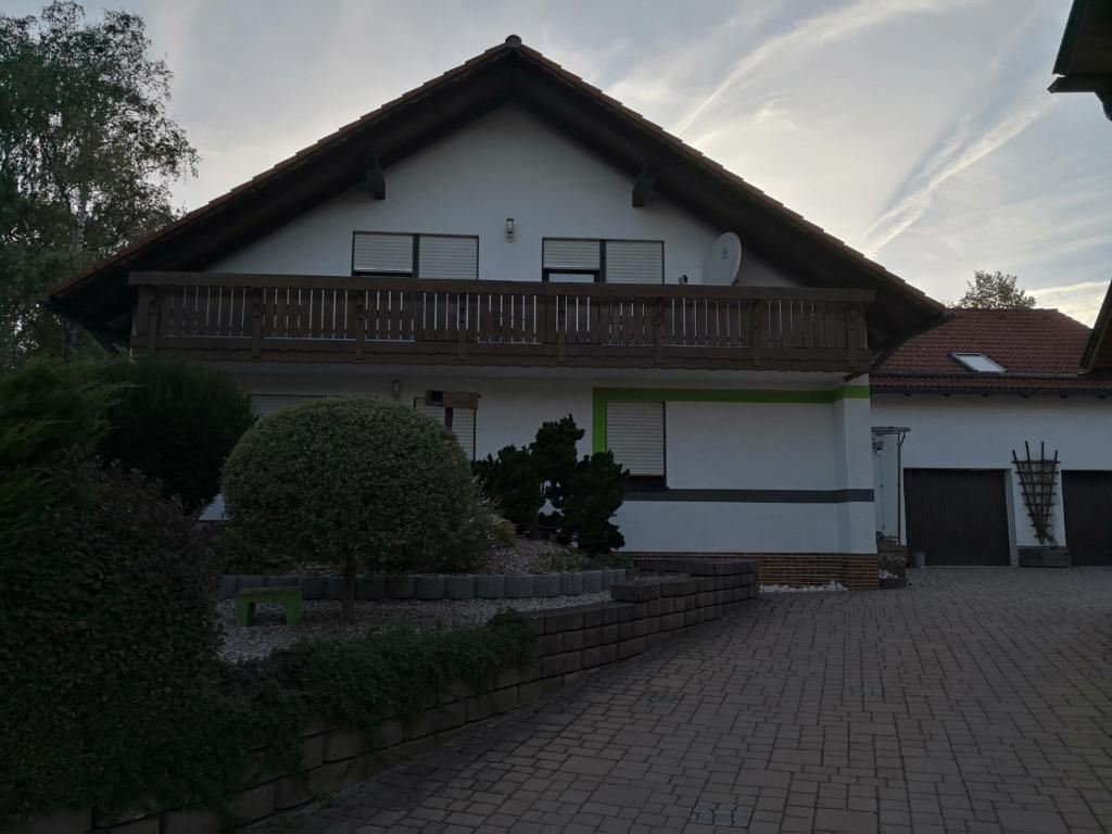 uma casa branca com um deck em cima em Ferienwohnung Schmeisser em Kirchenpingarten