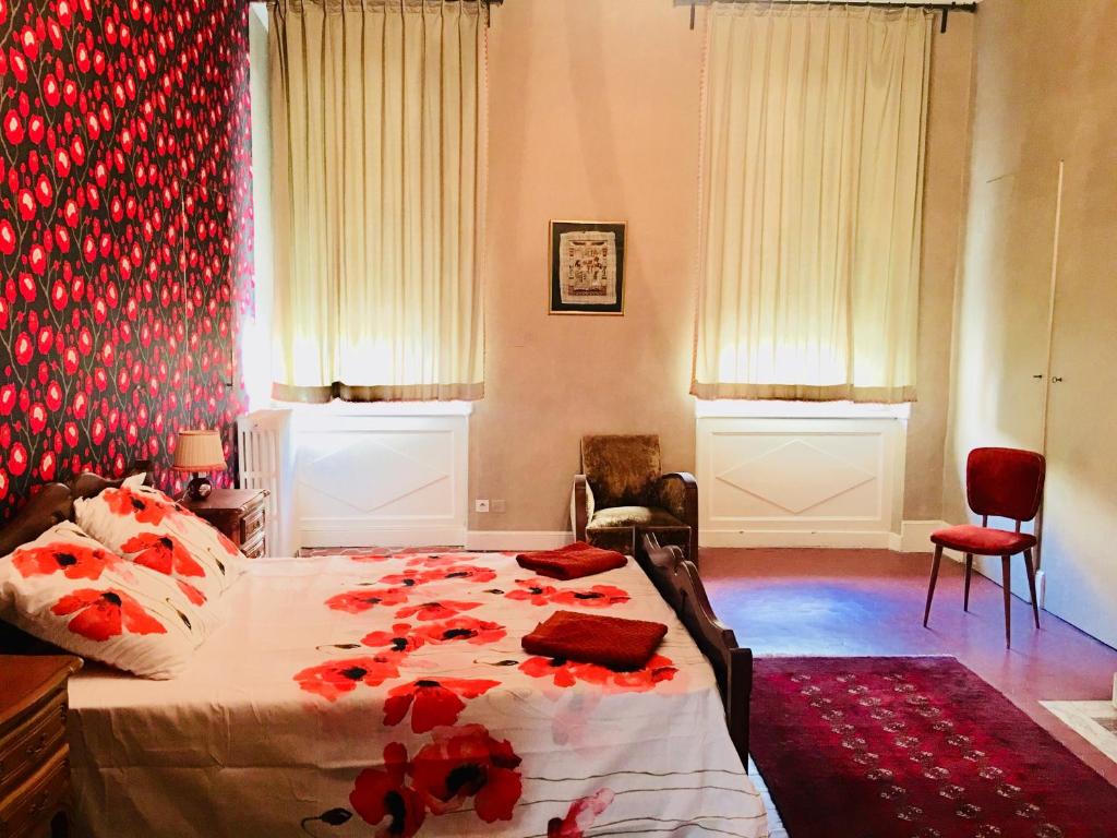 een slaapkamer met een bed met rode bloemen erop bij Les Chambres des Barques in Narbonne