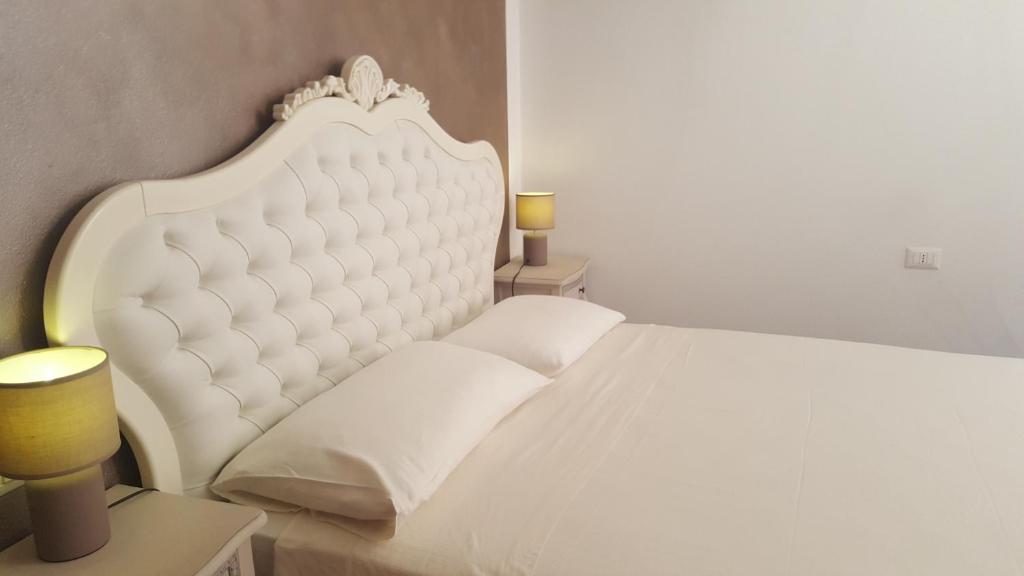 ラツィーゼにあるResidenza Via Rocca Treの白いベッド(白いパッド入りのヘッドボード付)が備わるベッドルームです。