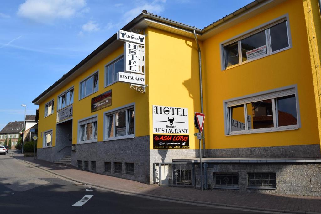 un edificio amarillo con letreros en el costado en Hotel zum Ochsen en Wonsheim