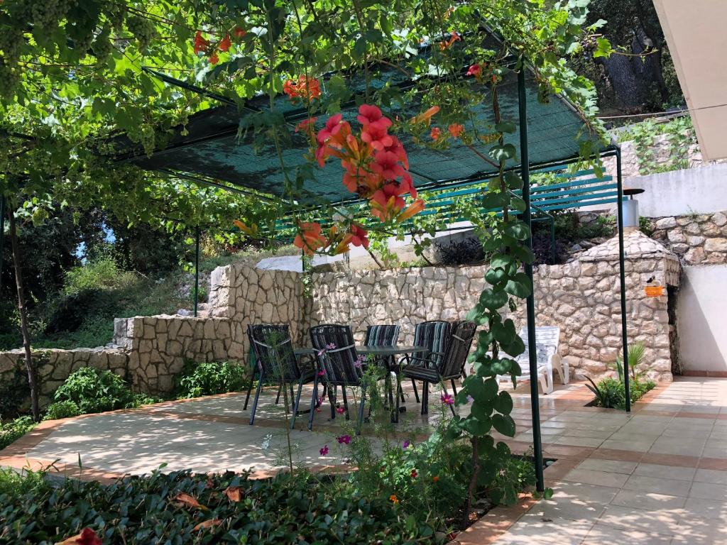 einen Tisch und Stühle unter einer Pergola im Garten in der Unterkunft Apartments Mila - Mala Duba in Živogošće