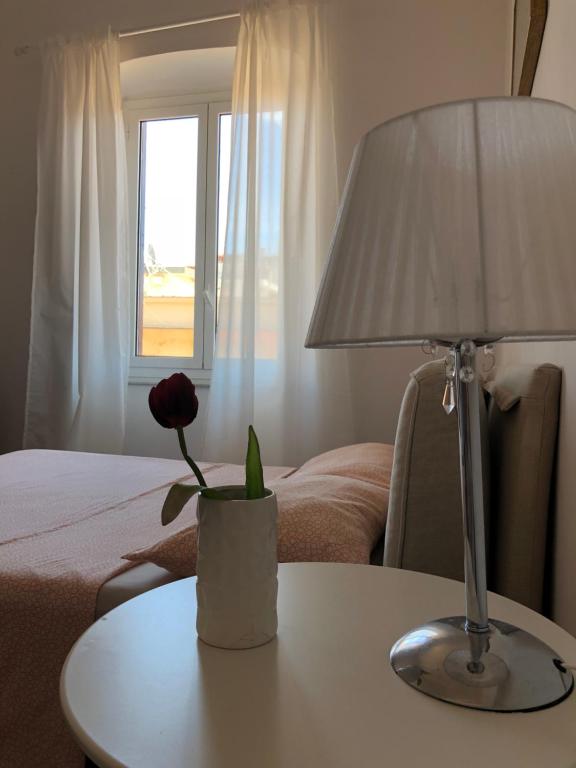 een tafel met een lamp en een vaas met een bloem erop bij The Gate to Cinque terre in La Spezia