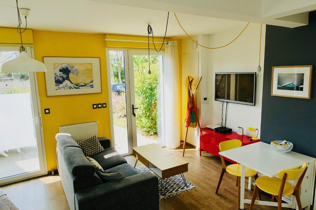 un salon avec un canapé et une table dans l'établissement Duplex Hermine Cosy, jardin sud & parking, à Saint-Malo