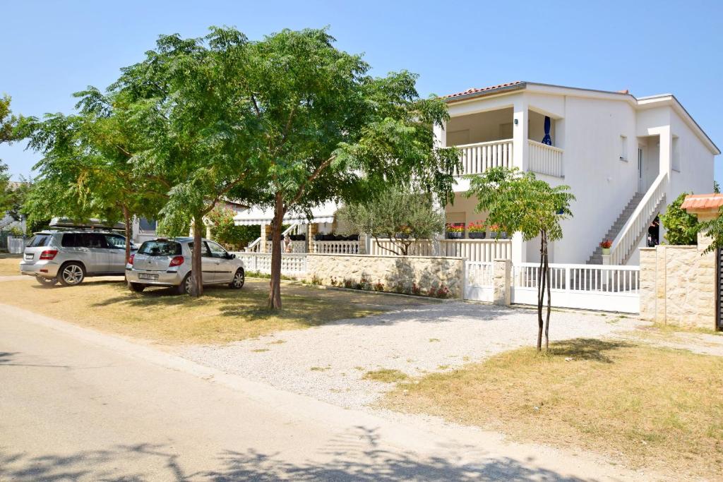 due auto parcheggiate davanti a una casa di Apartment DIVA a Nin
