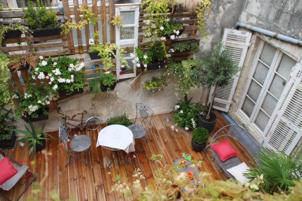 a balcony with a table and chairs and plants at Une Chambre en Ville in Saintes