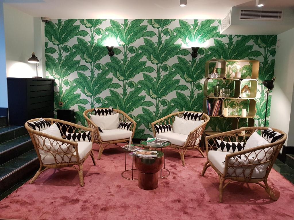 日內瓦的住宿－派克斯酒店，一间设有椅子、桌子和壁纸的等候室