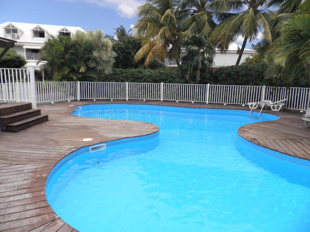 une piscine d'eau bleue et une clôture blanche dans l'établissement bienvenue à bord, à Saint-François