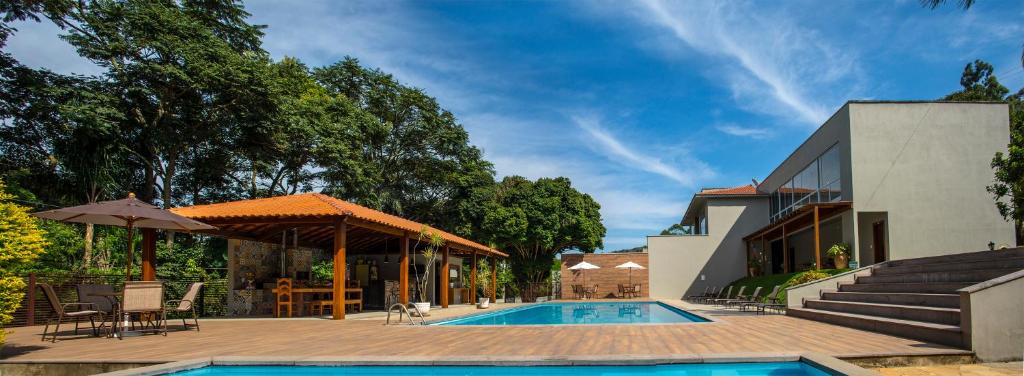 a house with a swimming pool and a patio at Pousada Recanto das Araras in Tiradentes