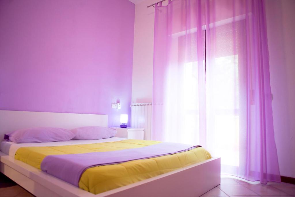 a bedroom with a bed with yellow sheets and a window at As Easy in Assisi