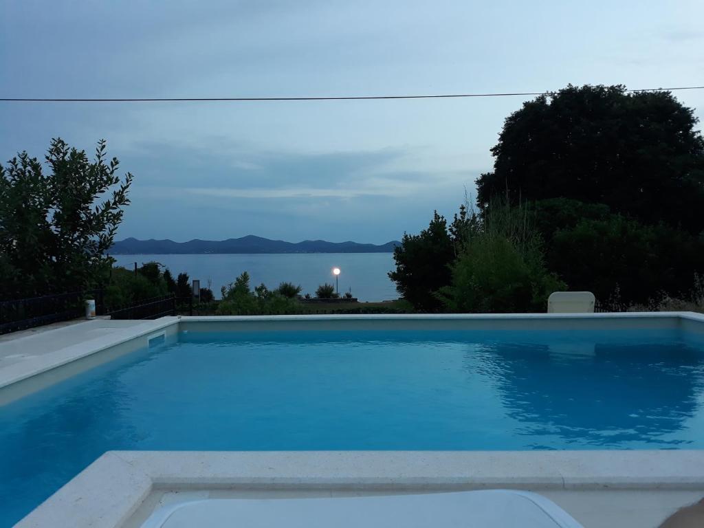 uma piscina com vista para a água em Janamari em Zadar