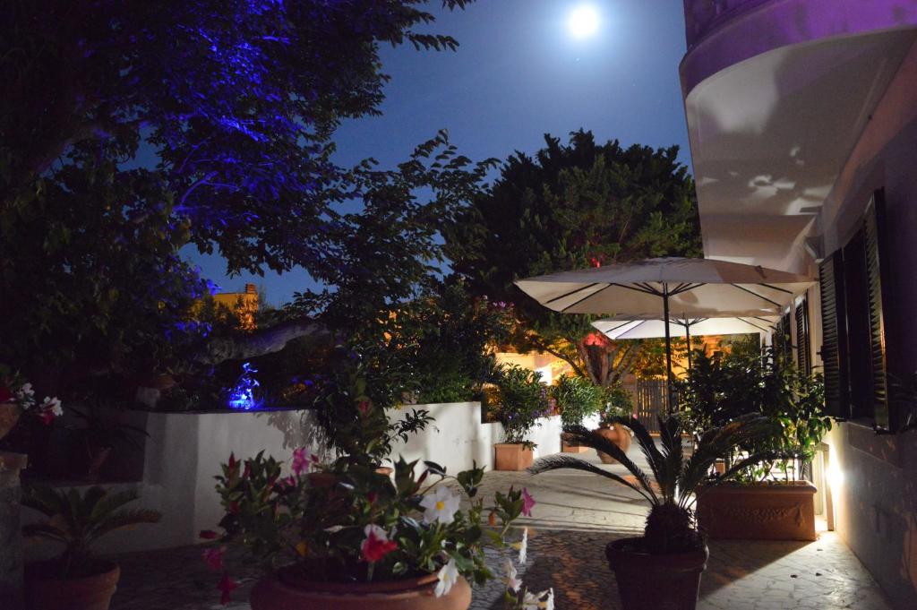 eine Terrasse mit Sonnenschirm und Topfpflanzen in der Nacht in der Unterkunft Casa di Arturo in Ventotene
