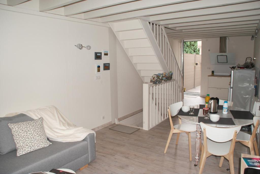een woonkamer met een bank en een tafel en stoelen bij Gîte ''Le nid de Bouly'' in Martres-de-Veyre