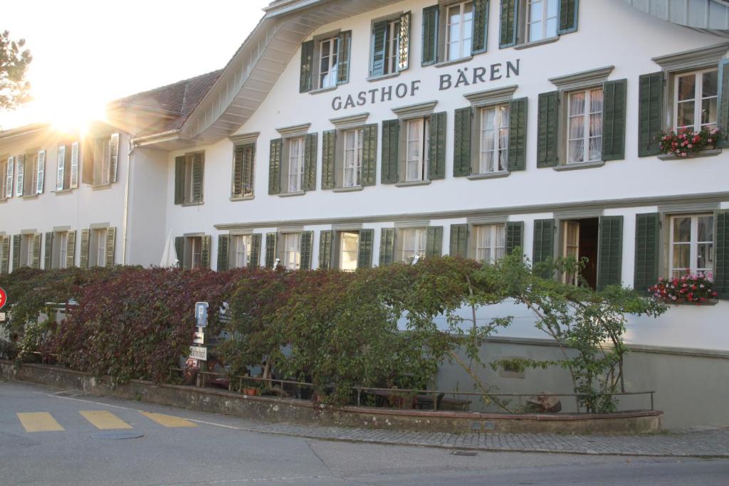 un edificio blanco con un cartel en la parte delantera en Gasthof Bären Laupen, en Laupen