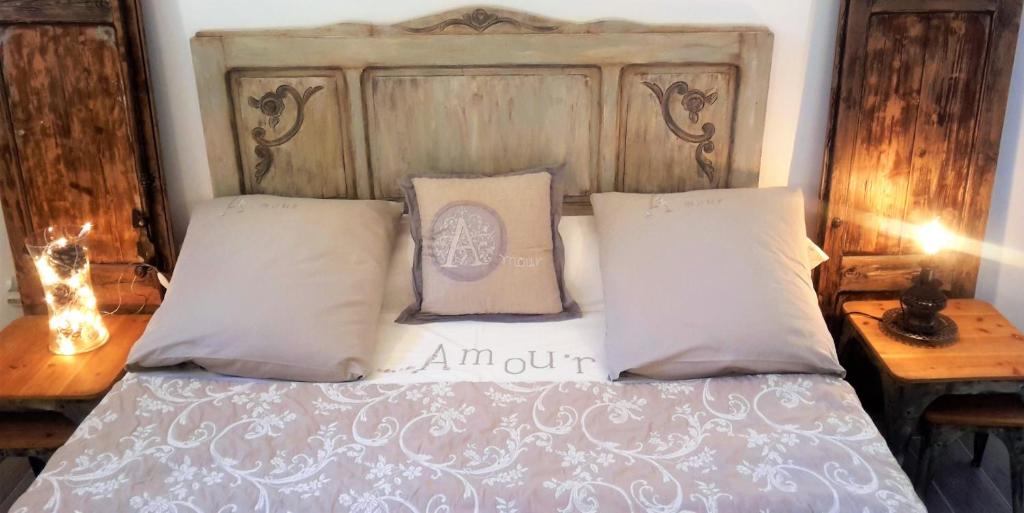 1 cama con cabecero de madera y 2 almohadas en Les pondres en vaunage, en Caveirac