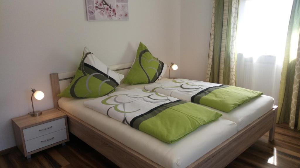 een slaapkamer met een bed met groene en zwarte kussens bij Landhaus Maria in Tettenweis