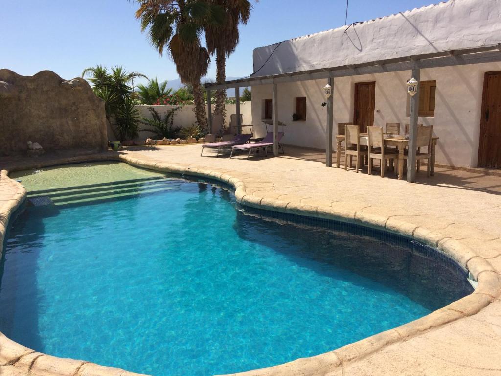 een zwembad met blauw water in een tuin bij Casa Pasy in Casas del Aljibe