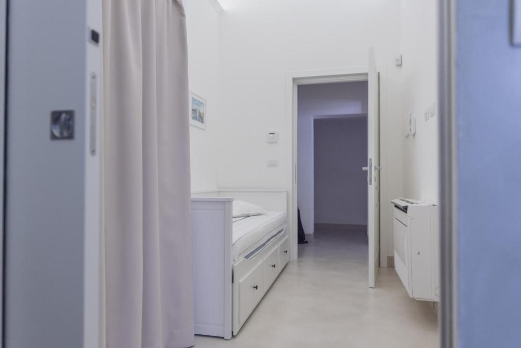 biały pokój z łóżkiem i lustrem w obiekcie CASA MELIO' w mieście Polignano a Mare