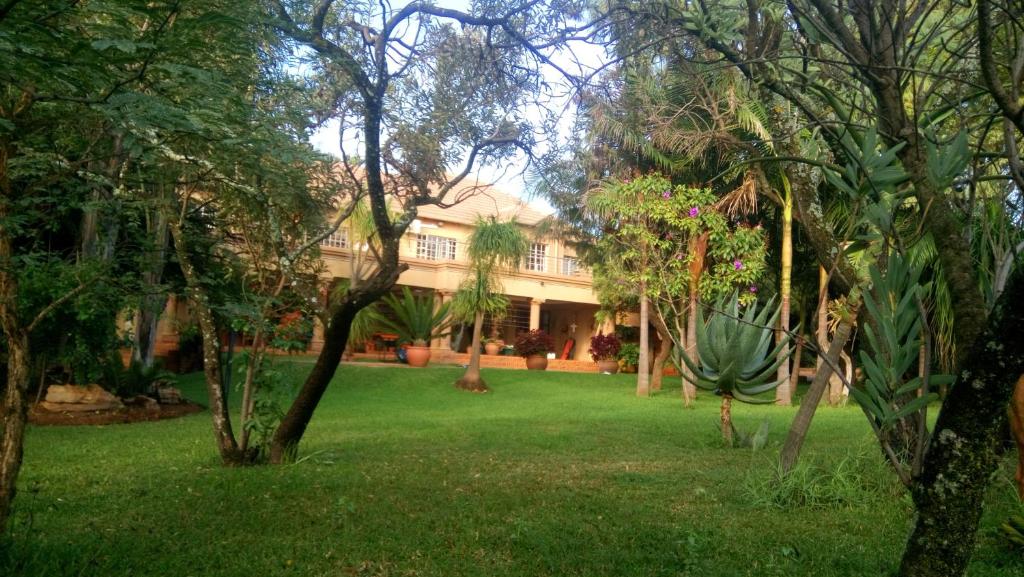 una casa en medio de un patio con árboles en Suikerbosrant Sleep and go, en Pretoria