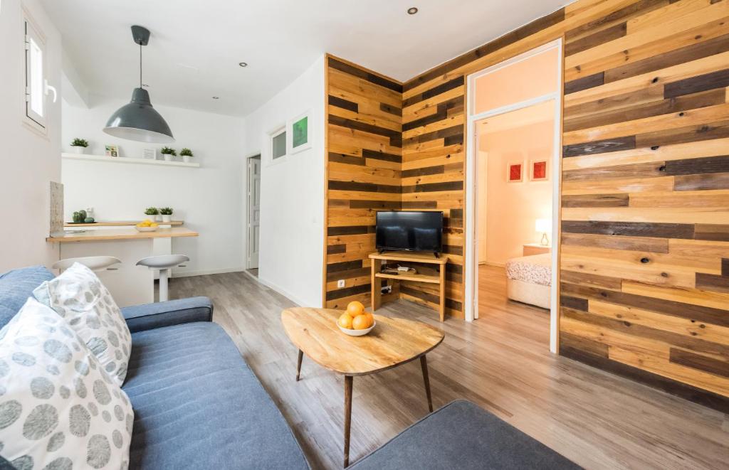 a living room with a blue couch and a wooden wall at Apartamento en SOL, Madrid Centro in Madrid