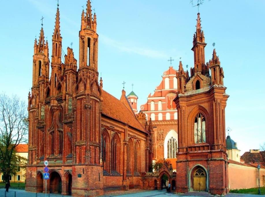 a large brick building with a large cathedral at Cozy Apartment in Gothic style house in the Heart of the Old Town in Vilnius