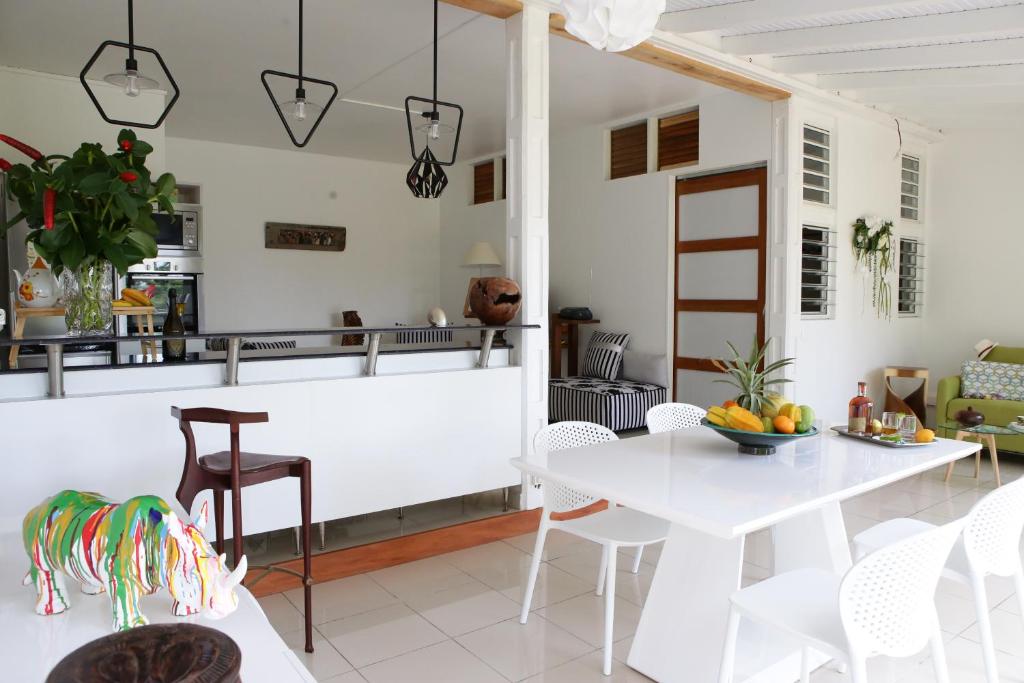 uma cozinha e sala de jantar com uma mesa branca e cadeiras em Le Talisman em Goyave