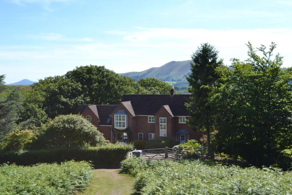 a house on the hill with mountains in the background at The Oaks in Church Stretton