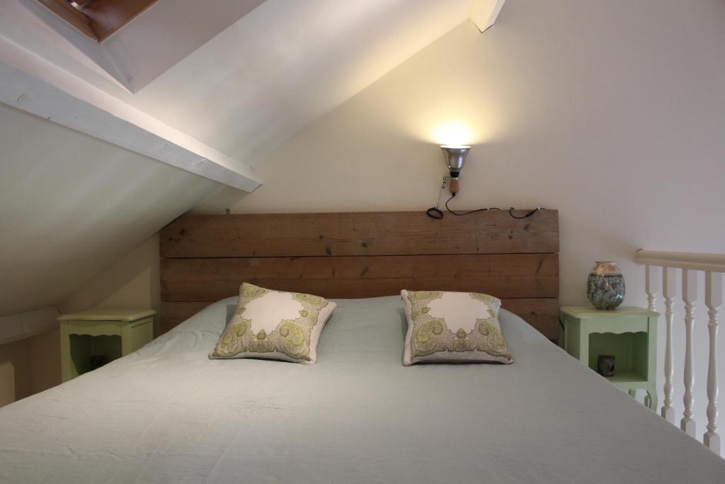 een slaapkamer met een wit bed met 2 kussens bij Het Huisje Breda in Breda