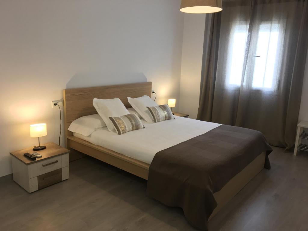 ein Schlafzimmer mit einem großen Bett und einem Fenster in der Unterkunft Apartamento San José by CasaTuristica in Ronda