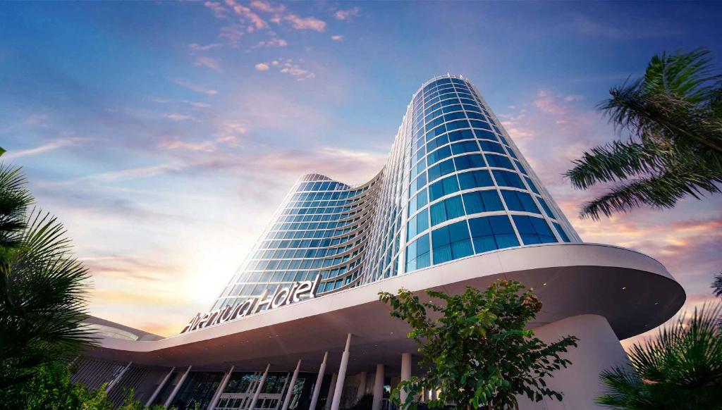 un edificio alto con la puesta de sol detrás de él en Universal's Aventura Hotel, en Orlando