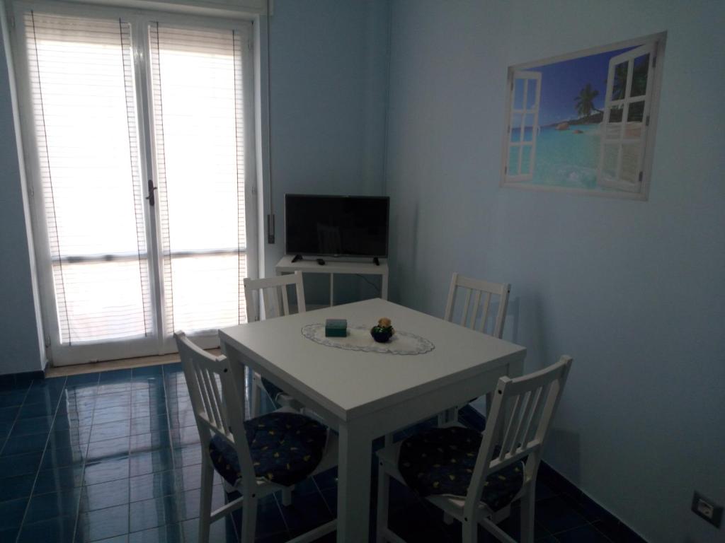 a dining room with a white table and chairs at La casa di Annisa in Maiori