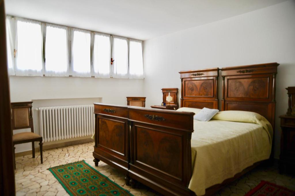 a bedroom with a large wooden bed and a window at Casa Foscolo in Ferrara