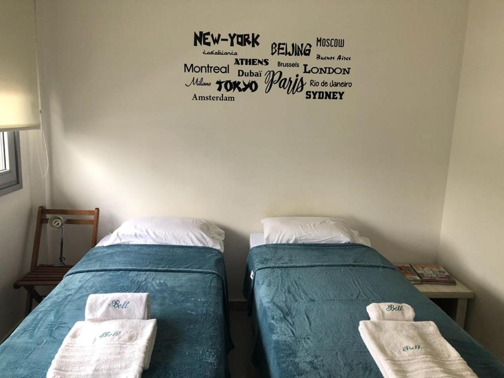 2 camas en una habitación con palabras en la pared en Bell 1 en Buenos Aires