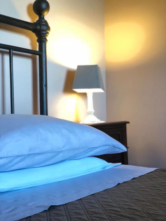 a bed with a blue pillow and a lamp at Agriturismo Podere Pescara in Orvieto